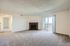 Inviting living room featuring a soft carpet, brick fireplace, and sliding glass doors to a balcony.