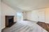 Bright, carpeted living room featuring a classic brick fireplace and sliding glass door to balcony.