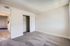 Inviting empty bedroom with soft gray carpeting and a sliding closet door.