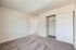 Bright and clean bedroom featuring plush carpet and a built-in sliding door closet.
