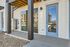 Chic apartment entrance with modern glass doors and stylish wood accents, reflecting a vibrant community ambiance.