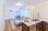 Bright and welcoming living space with open-plan design featuring a comfortable sofa and modern kitchen with a marble countertop, perfect for entertaining.