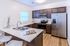 Modern kitchen with elegant marble countertops, stainless steel appliances, and stylish wooden cabinetry, offering a spacious and inviting cooking space.