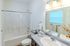Bright and modern bathroom with elegant fixtures, crisp white tiles, and abundant natural light, creating a serene spa-like atmosphere.