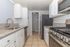 Sleek modern kitchen with granite countertops, stainless steel appliances, and white cabinetry, exuding elegance and functionality.
