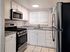 Modern kitchen with granite countertops, stainless steel appliances, and bright white cabinetry, offering a stylish and functional cooking space.