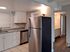 Bright modern kitchen with sleek stainless steel appliances, elegant granite countertops, and pristine white cabinetry, offering a stylish and functional space.