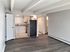Modern apartment interior with an open-concept layout, featuring a sleek kitchen with stainless steel appliances, spacious living area with elegant flooring, and contemporary lighting.