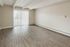 Bright and spacious living room with elegant wood flooring and large sliding glass doors leading to a sunlit balcony.
