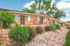 Charming brick apartment complex with lush greenery and inviting patio seating, perfect for enjoying the outdoors.