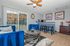 Charming living room with modern decor, featuring plush blue armchairs, a stylish coffee table, and a cozy breakfast bar.
