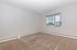 Bright, spacious room with fresh carpet, large window, and modern air conditioning unit, perfect for comfortable living.