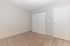 Inviting empty room with plush carpet and double white closet doors, offering a blank canvas for any decor style.