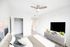 Bright and modern bedroom featuring sleek decor, a stylish ceiling fan, and ample closet space.