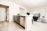 Modern open-plan living area featuring a stylish kitchen island, stainless steel appliances, and a cozy seating space with natural light.