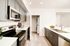 Sleek modern kitchen featuring stainless steel appliances, stylish cabinetry, and a convenient in-unit washer and dryer.