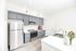 Bright and modern kitchen with sleek stainless steel appliances, stylish gray cabinets, and elegant white countertops, perfect for culinary creativity.