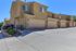 Charming townhouse with spacious double garage, beautiful landscape, and modern exterior in a serene residential community.