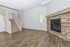 Inviting living room with elegant hardwood floors, stylish stone fireplace, and contemporary staircase.