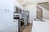 Modern kitchen with sleek white cabinetry, stainless steel appliances, and elegant countertops, perfect for culinary enthusiasts.
