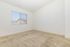 Bright and inviting bedroom with plush carpet, large window, and ample natural light.