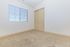 Bright and cozy bedroom with plush carpet and large window, perfect for natural light and tranquility.