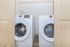 Modern laundry room with sleek Samsung washer and dryer, featuring hardwood flooring and ample shelving space.