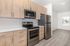 Modern kitchen with sleek stainless steel appliances, elegant light wood cabinets, and spacious countertops, perfect for culinary enthusiasts.