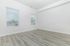 Bright, spacious room with large windows and elegant hardwood flooring, perfect for versatile living space.
