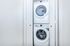 Modern apartment laundry space featuring sleek, stacked washer and dryer within a convenient closet.