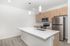 Sleek modern kitchen featuring stainless steel appliances, elegant pendant lighting, and a spacious white countertop.