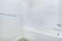 Sleek and modern bathroom featuring a pristine white bathtub with chrome fixtures, perfect for relaxation.