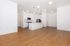 Bright modern kitchen with sleek white cabinetry, stainless steel appliances, and elegant pendant lighting over a spacious island, enhanced by rich wood flooring.