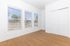 Bright and airy room with large windows, offering abundant natural light and a scenic outdoor view, featuring modern wooden flooring and sleek white walls.