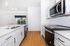 Modern kitchen with sleek stainless steel appliances, elegant pendant lighting, and expansive windows offering a serene view.