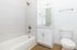 Bright and modern bathroom featuring a sleek bathtub, elegant vanity, and contemporary fixtures.