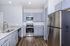 Modern kitchen with sleek stainless steel appliances, granite countertops, and elegant cabinetry in a bright, open space.