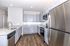 Modern kitchen with sleek granite countertops, elegant gray cabinetry, and stainless steel appliances.