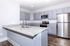 Modern kitchen with sleek granite countertops, stainless steel appliances, and elegant gray cabinetry.