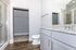 Bright modern bathroom with elegant granite countertops, sleek cabinetry, and spacious walk-in closet.