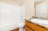 Bright and spacious bathroom featuring a pristine white bathtub.