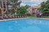 Inviting swimming pool area with stylish loungers and a serene apartment backdrop, perfect for relaxation and leisure.