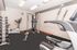 Modern fitness room equipped with state-of-the-art exercise machines, including a treadmill, stationary bike, weight rack, and multifunctional gym equipment.