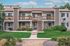 Charming apartment building with balconies set in lush green surroundings, featuring stylish architecture and peaceful living.