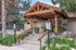 Inviting entrance with wooden pergola at leasing office, surrounded by lush greenery and clear signage for future resident parking.