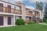Charming apartment complex with stylish wooden balconies and lush greenery, perfect for a tranquil living experience.