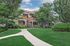 Charming two-story apartment complex nestled among lush greenery with a welcoming pathway and wooden balconies.