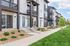 Modern townhouse exterior with sleek design, large windows, and inviting landscaping, offering a vibrant community ambiance.