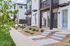 Chic modern townhomes with stylish facade, landscaped front yards, and welcoming blue doors.
