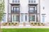 Modern apartment facade showcasing sleek design with private balconies and vibrant landscaping.